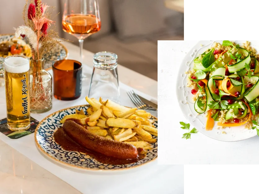 Heimat • Currywurst mit Pommes und Bier, daneben frischer Salat mit Gurke, Karotte und Granatapfelkernen