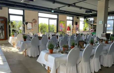 Heimat Vermietung • Festlich gedeckte Tische mit weißen Stuhlhussen und Dekoration