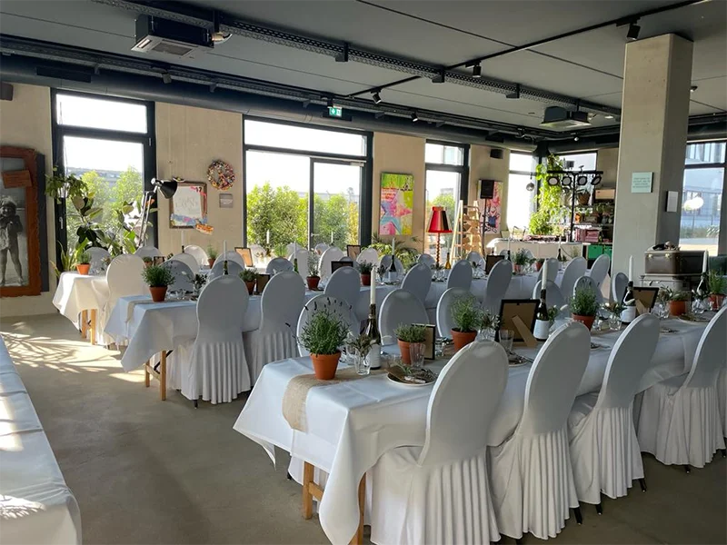 Heimat Vermietung • Festlich gedeckte Tische mit weißen Stuhlhussen und Dekoration
