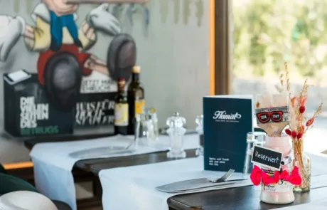 Heimat • Restauranttisch mit Reserviert-Schild und Pinocchio-Graffiti